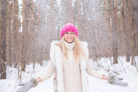 年轻女子扔雪的肖像。微笑的女孩走在冬季公园, 并在寒冷的阳光明媚的户外享受