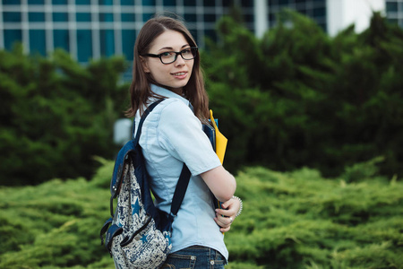 学生女孩画像在学院或大学附近保存文件夹准备学习