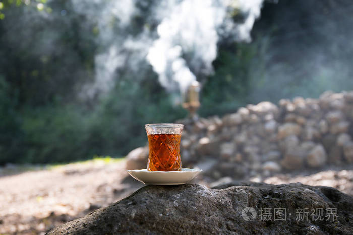 在森林的石头上玻璃上的东方红茶东方茶的概念armudu传统杯绿色自然