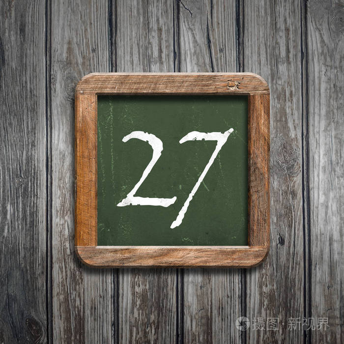 数字27在绿色黑板在木背景之上