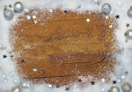在银色圣诞节装饰和星星在雪的山顶看法在木板背景