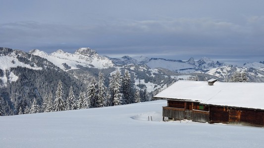 雪覆盖的山峦和旧的小屋