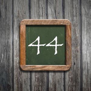 数字44在绿色黑板在木背景之上