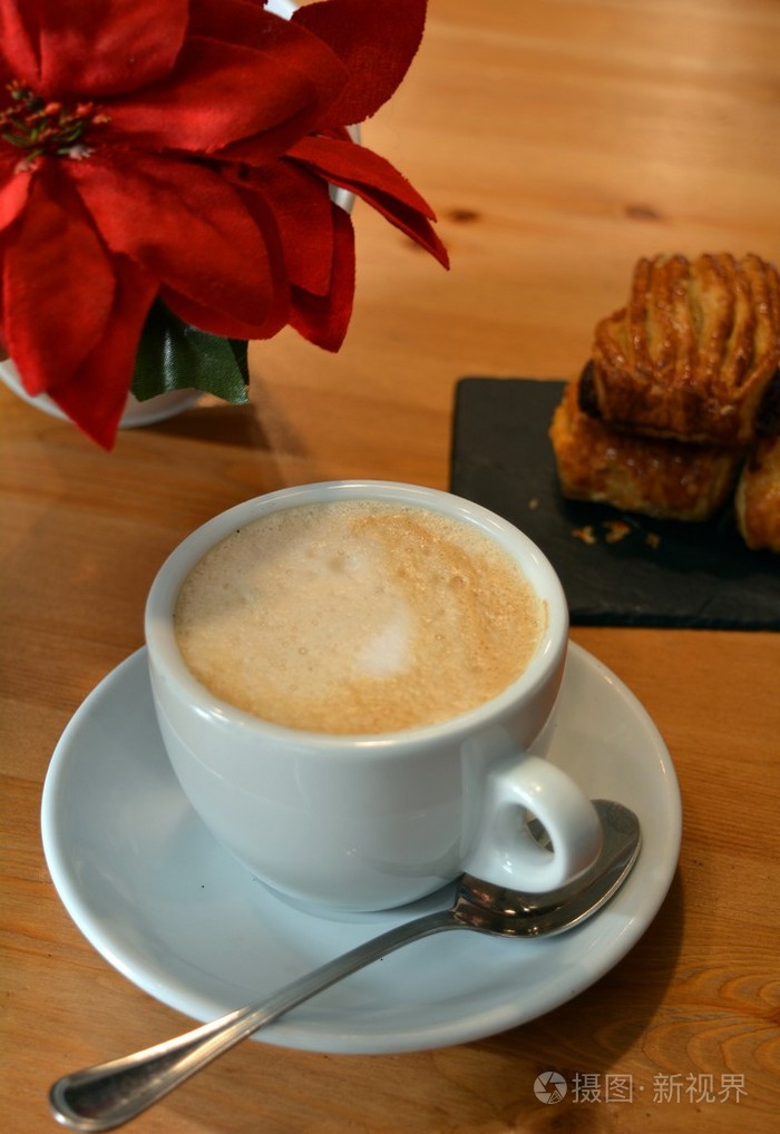 杯热咖啡和木制的桌子上的小披萨