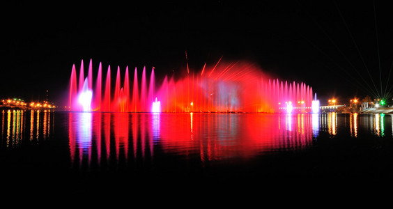 惊人的舞蹈喷泉在夜晚亮起红色 蓝色和绿色