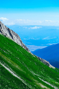 美丽的高山山峰, 蓝天背景, 夏日。徒步穿越惊人的绿色田野, 景观