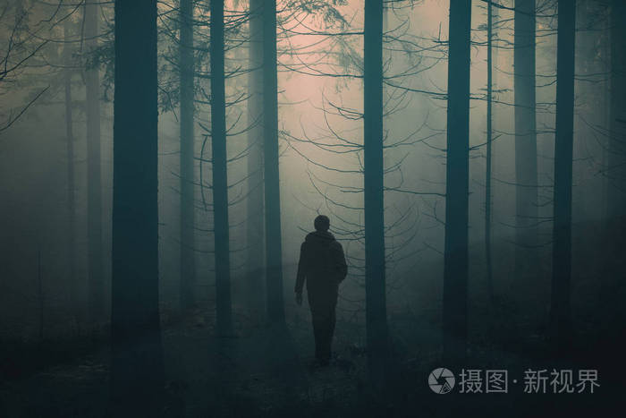 男子独自走在雾蒙蒙的农村雾蒙蒙的森林路上.使用的双重曝光