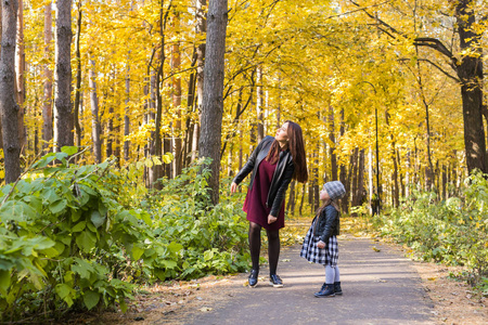 人, 家庭和休闲概念年轻母亲走与她的女儿在秋季公园
