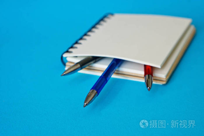 内存项。有彩色钢笔的笔记本位于蓝色的表面上。