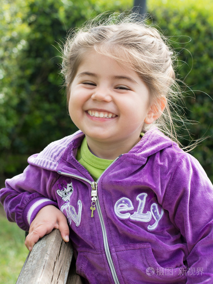 小女孩微笑着在公园里玩的肖像
