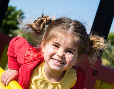 小女孩微笑着，在公园里玩的肖像