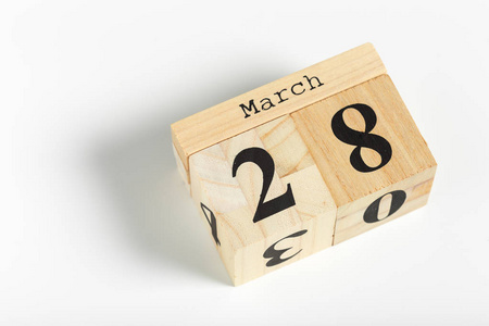 木立方体与日期在白色背景3月28日照片