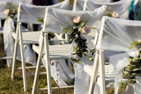在户外婚礼仪式上为客人布置的椅子。美丽的婚礼花卉装饰