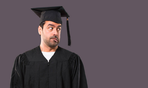 大学毕业的时候, 男人有点紧张, 害怕在紫罗兰色的背景下按牙齿