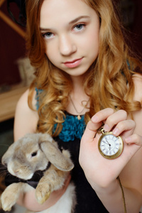   的形象一个年轻女孩拿着兔和口袋手表