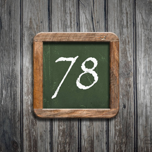 数字78在绿色黑板在木背景之上