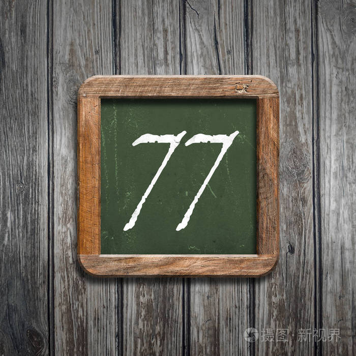 数字77在绿色黑板在木背景之上