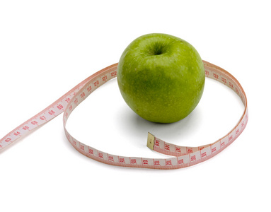 一个绿色的苹果和测量磁带