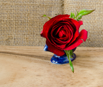 红玫瑰和珍珠镶嵌在木制的地板和麻袋纹理背景元素设计