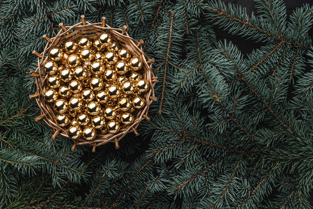 杉木树枝的冬天背景。篮子金色小玩意。圣诞贺卡顶部视图。圣诞祝贺