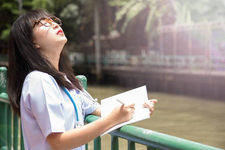 女亚裔医生白衬衫套装与 stetho 范围户外医院