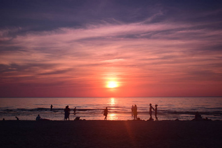 海滩与人剪影在日落背景