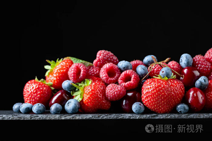 浆果特写五颜六色的混合草莓蓝莓覆盆子和甜樱桃在工作室黑色背景