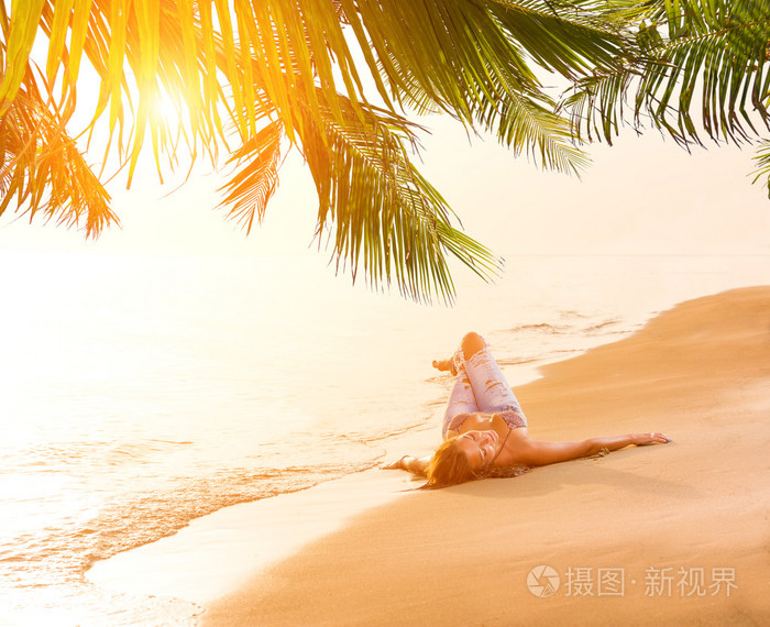 蓝色的牛仔裤和比基尼在海滩的女人