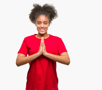 年轻的美国黑人妇女在孤立的背景祈祷双手一起请求原谅微笑自信