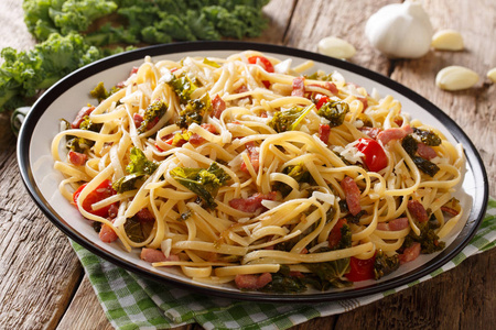 意大利菜 面食扁面条浇与油炸培根, 蔬菜和干酪干酪特写在桌子上的盘子。horizonta