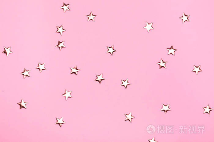 金色的星星在粉红色的背景上闪闪发亮.节日柔和的背景