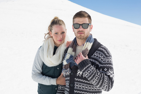 夫妇在暖和的衣服被雪覆盖的风景