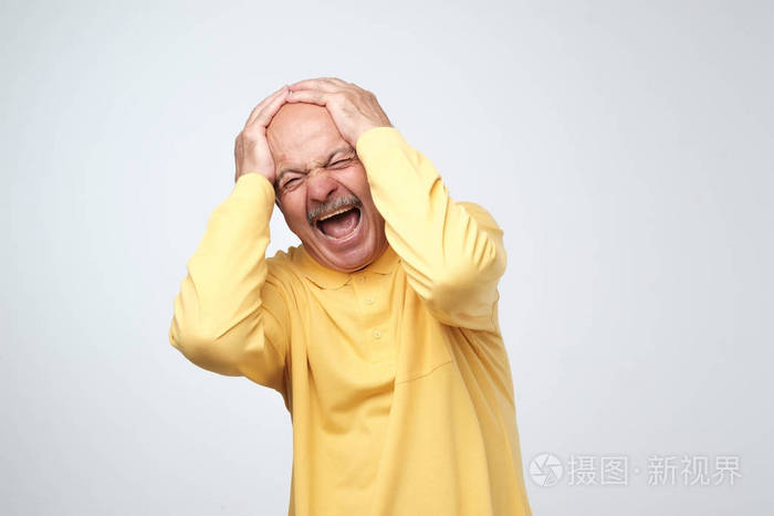 停止那个响亮的噪音概念.成熟的男人在黄色的 t恤遭受大声的音乐和痛