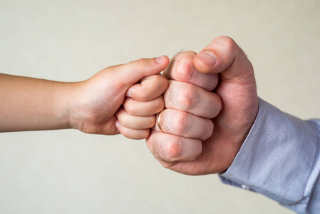 比赛和胜利, 一个孩子的拳头和一个成年男性特写.领导和优胜者照片