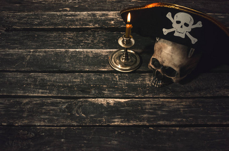 海盗船长表与海盗帽子, 人类头骨和燃烧的蜡烛。寻宝概念背景