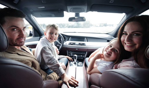 关闭. 微笑的家庭坐在舒适的汽车