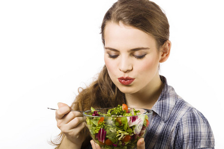 吃蔬菜沙拉孤立在白色背景上的年轻女子