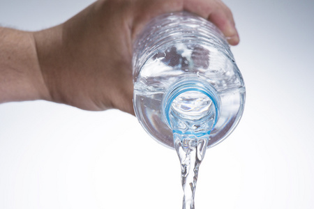 玻璃水的瓶子从手倒水照片