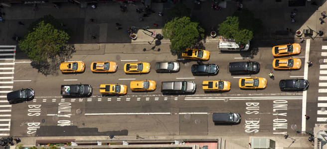 从纽约市街道上的摩天大楼可以看到。在街上可以看到路上有汽车的最高景色。黄色出租车在纽约市