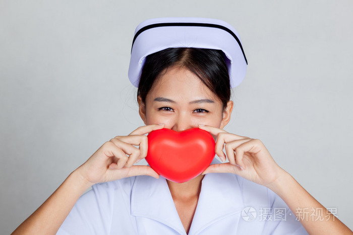 亚洲年轻护士笑容带上红色的心