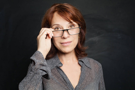 一个年迈的妇人,她在浇花用软管高级女子肖像一个成熟的老年妇女的