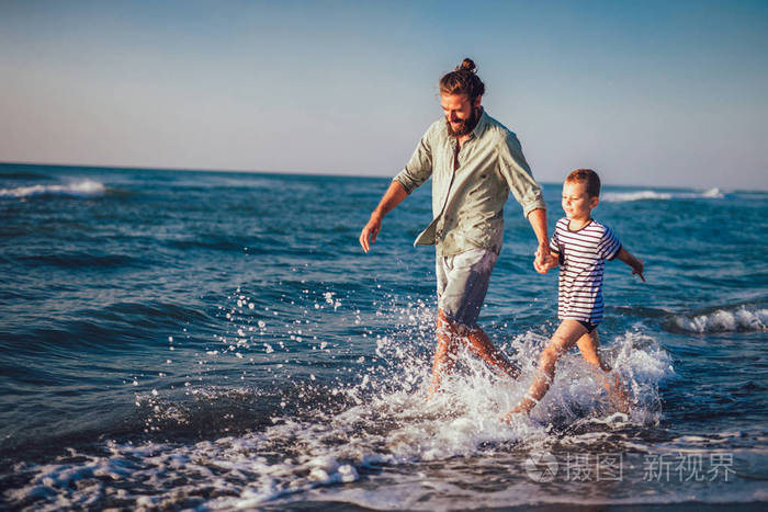 快乐的父亲和儿子, 男人和男孩的孩子, 在沙滩上奔跑, 在阳光明媚的