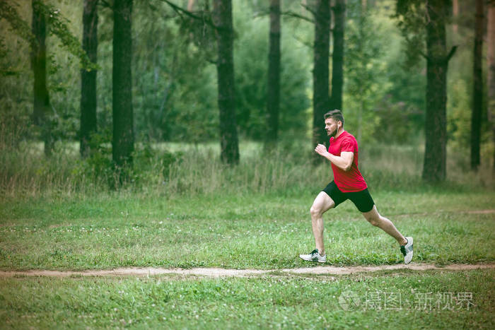 在公园里慢跑的男跑步者.在户外训练的人在森林小径上锻炼.