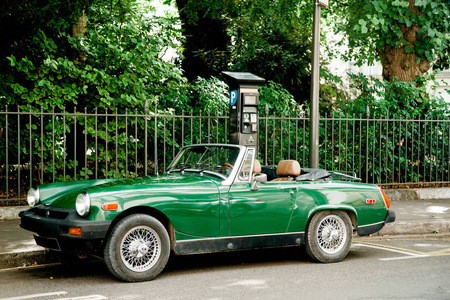 夏日大街上闪亮的绿颜色复古老式汽车照片