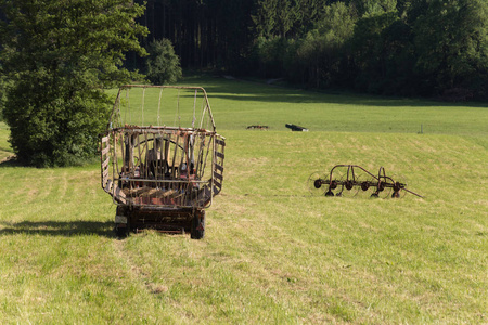 6月在德国南部农村的阳光明媚的夜晚, 哈影与一个古老的拖拉机在夏季场的老