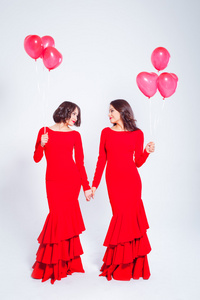 两个年轻漂亮的女性穿着长长的红气球