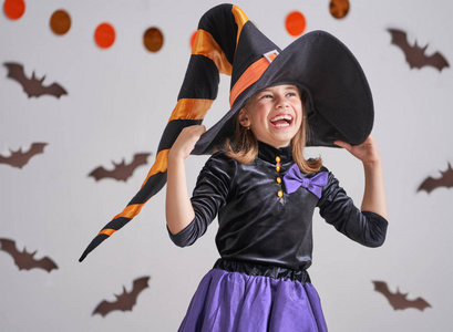 可爱的小笑的女孩在巫婆服装照片