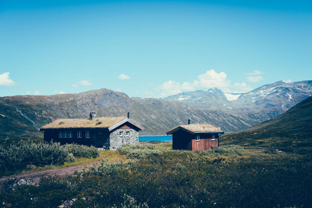 Jotunheimen 国家公园风景在 Oppland, 挪威。老传统挪威小屋在山湖的海岸和在背景的山