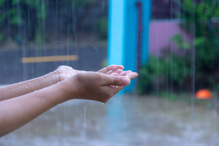 下雨天伸出手接雨滴图片