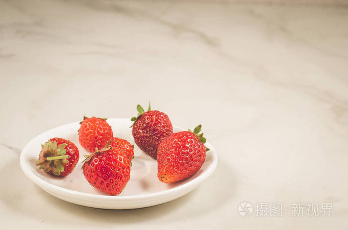 新鲜草莓浆果在碗新鲜草莓浆果在一个碗上的白色大理石背景, 复制空间和选择性焦点